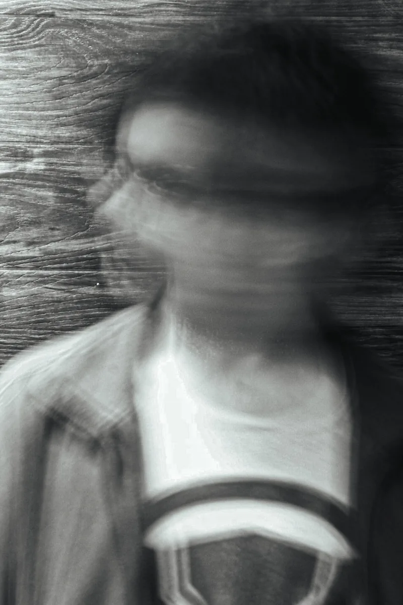 Black and white portrait of a Toronto photographer in motion, face blurred by a slow shutter